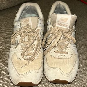Women’s New Balance 574 size 9 color is cream and tan.